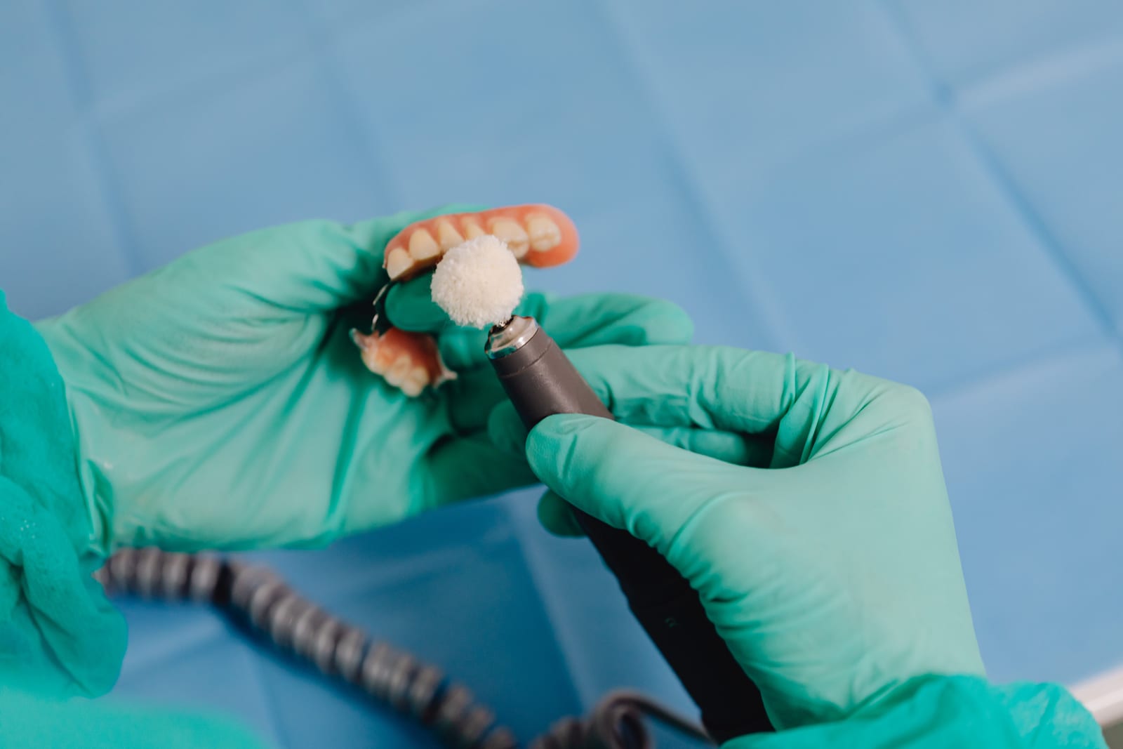 A technician polishing a denture at the lab bench.